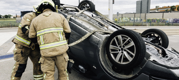 Firefighters work in traffic accident. Car overturned on public road