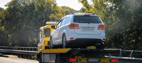 Tow truck with a car on the road