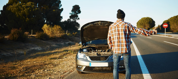 Cars - driver trying stop car in travel because his car broken. Young man stand on freeway and shows thumbs up. Young interracial man in their twenties, Caucasian man.